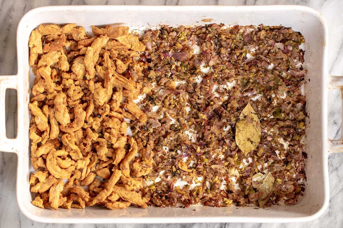 baking pan with soy curls on one half and aromatics and spices on the other half, after baking