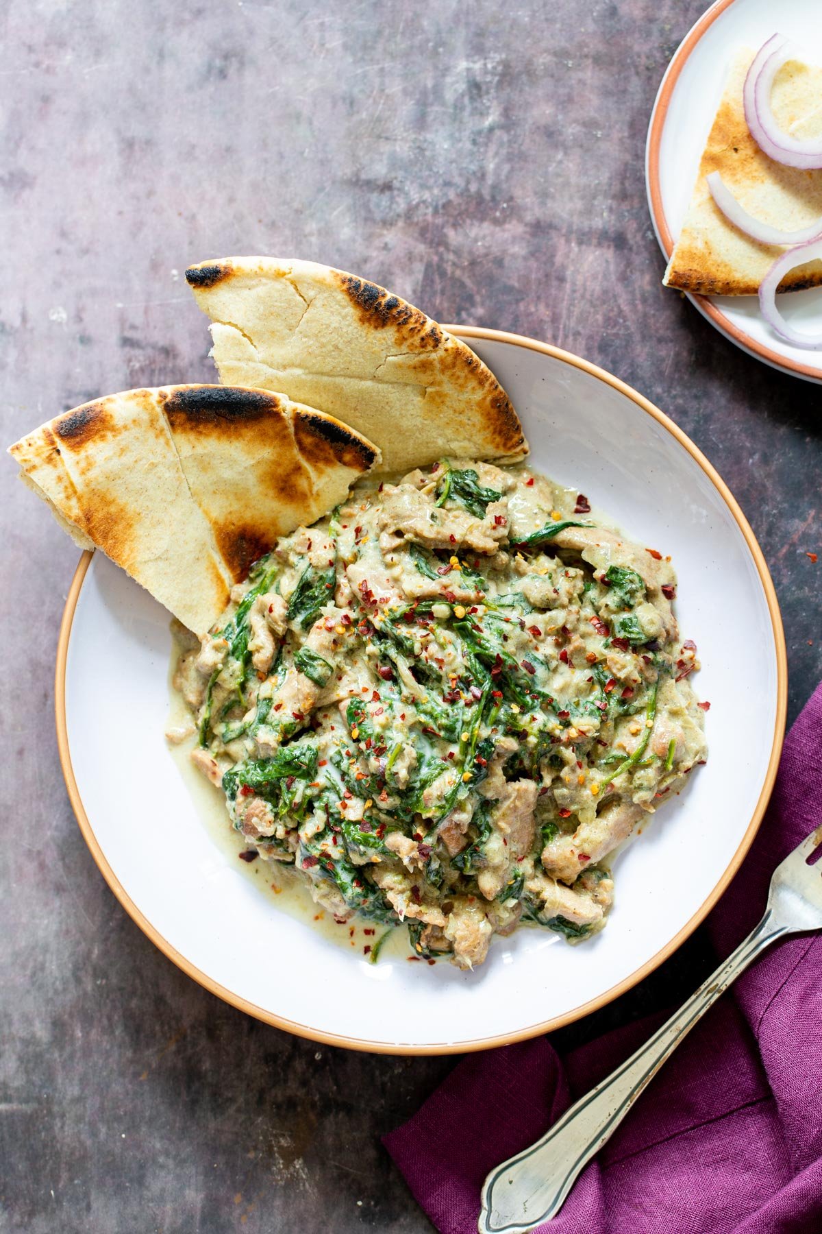 baked Malai Palak Chicken with soy curls in a bowl with naan