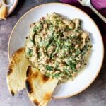 baked Indian spinach curry with soy curls in a bowl with naan