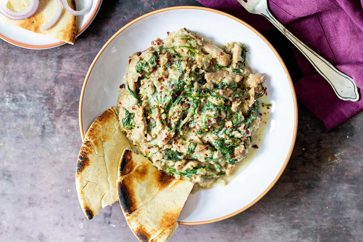 Malai Palak Chicken in a bowl with naan