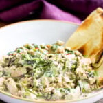 close-up of baked Indian spinach curry with soy curls in a bowl with naan