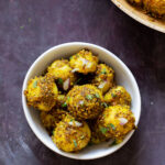 peanut sesame potatoes in a bowl next to the frying pan