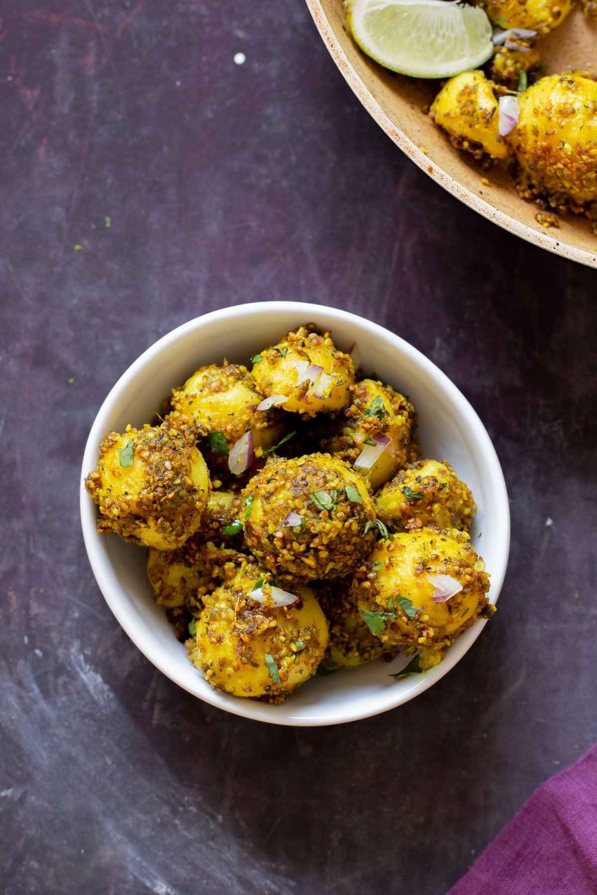 peanut sesame potatoes in a bowl next to the frying pan