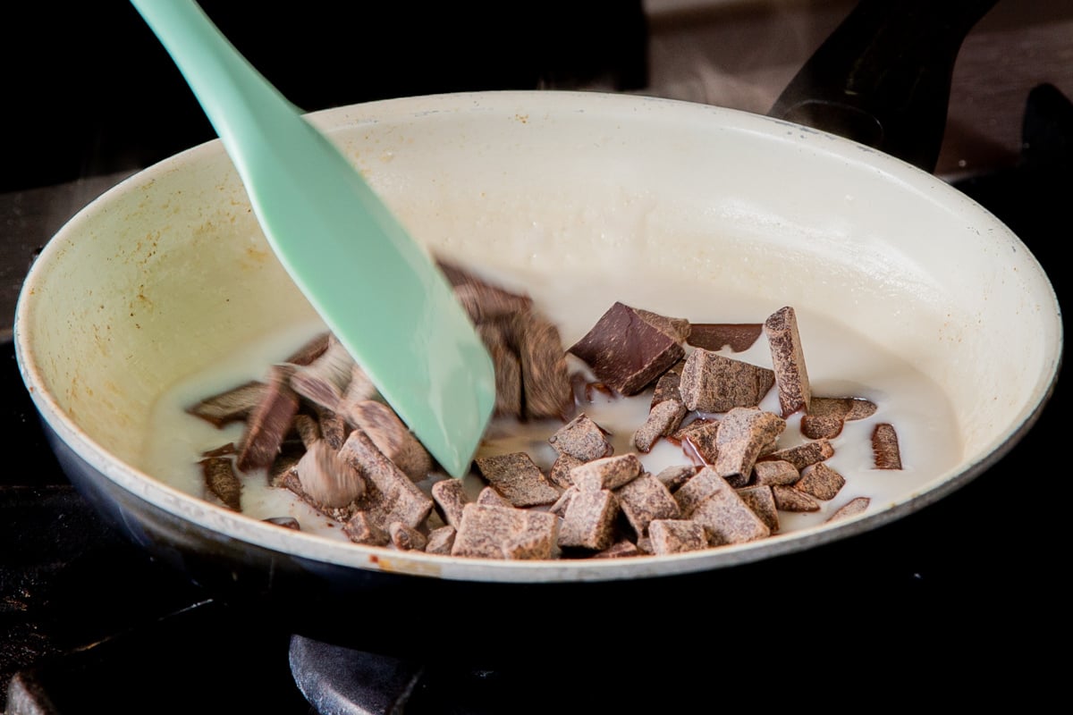 adding chocolate chunks to the melted coconut cream