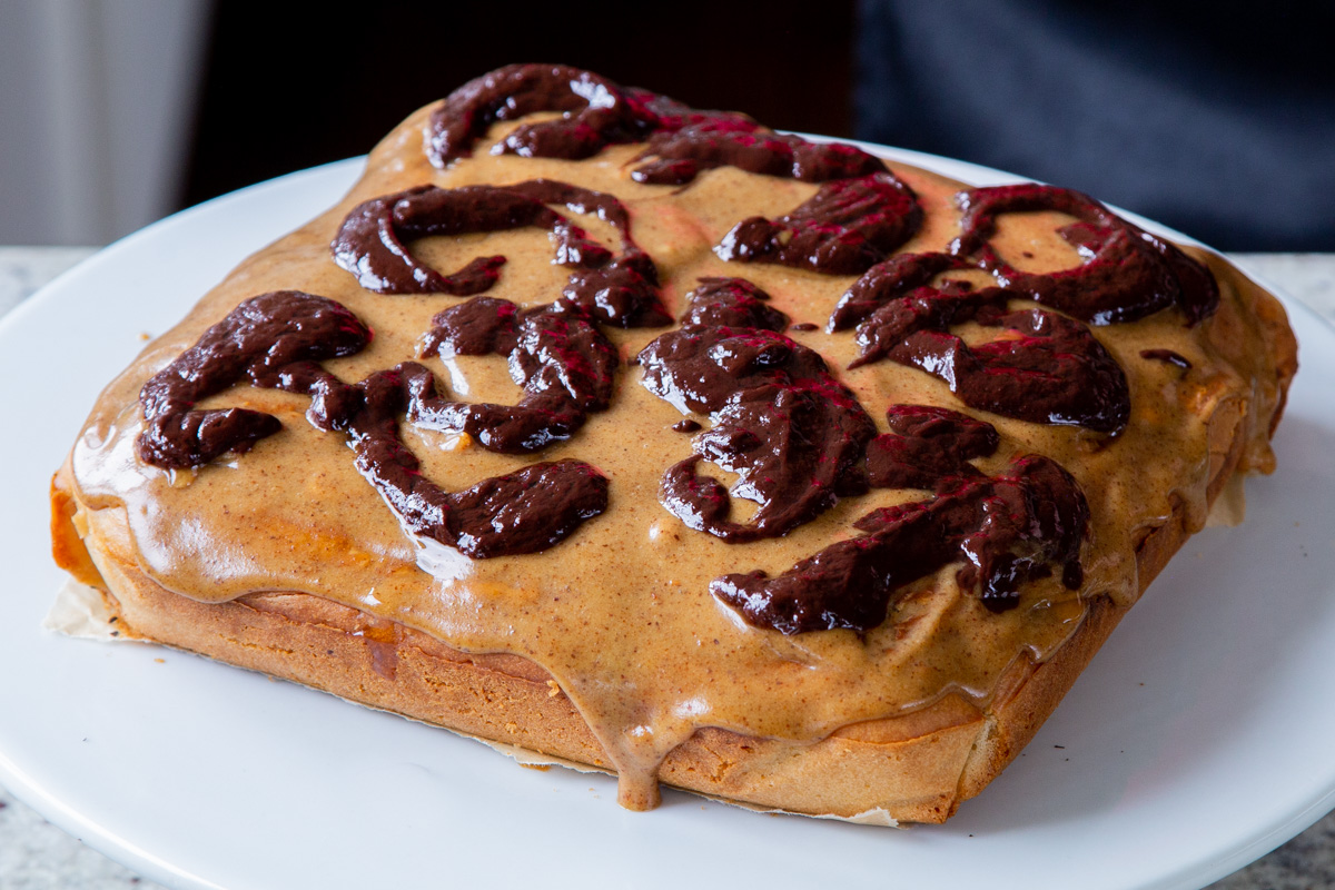 adding melted chocolate to the Snickers cake