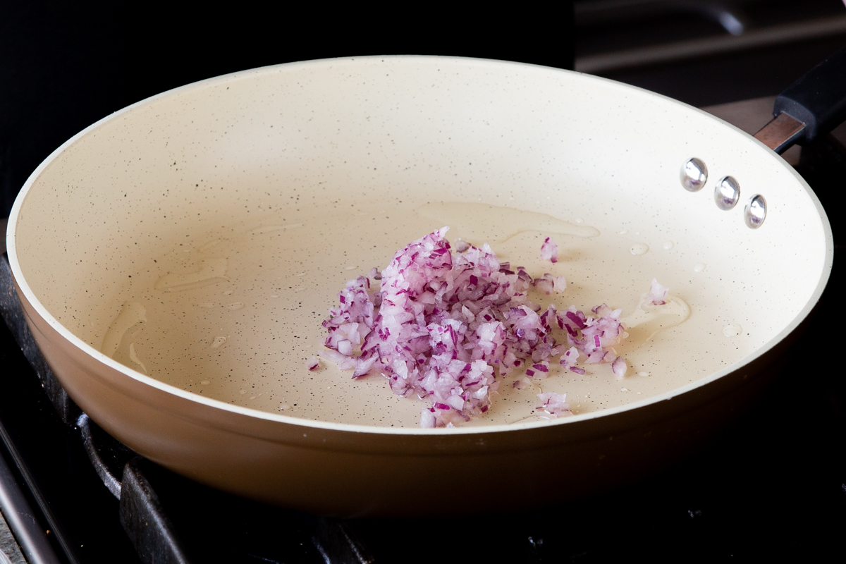 adding onion to the frying pan