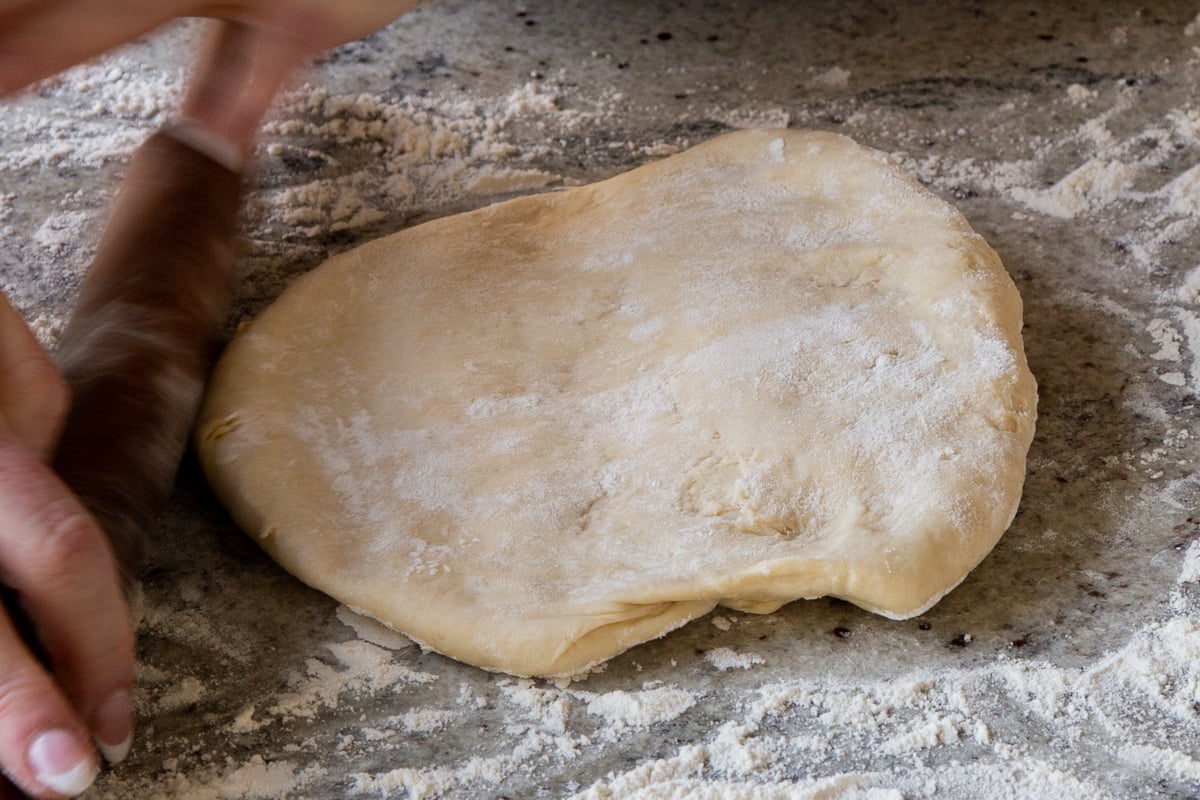 dough on a floured surface, before rolling it out