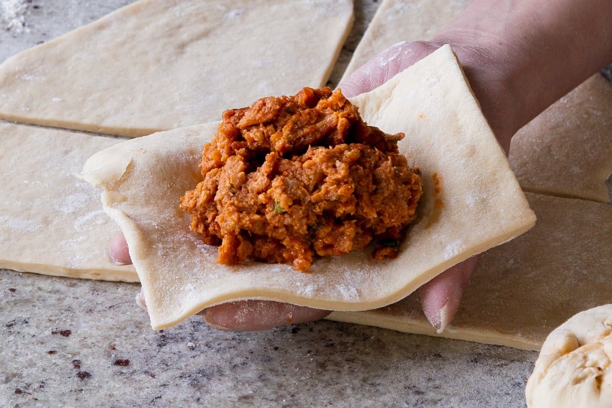adding filling to a square of dough