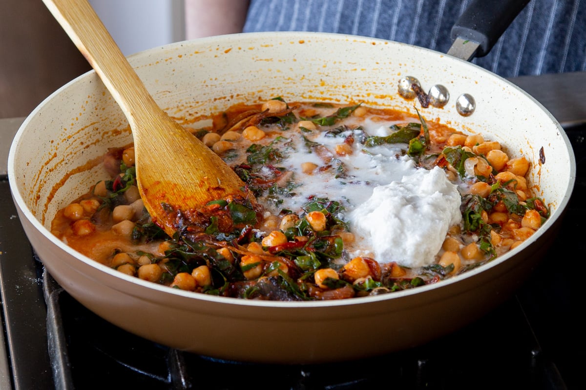 adding coconut cream to the harissa-chickpea mixture