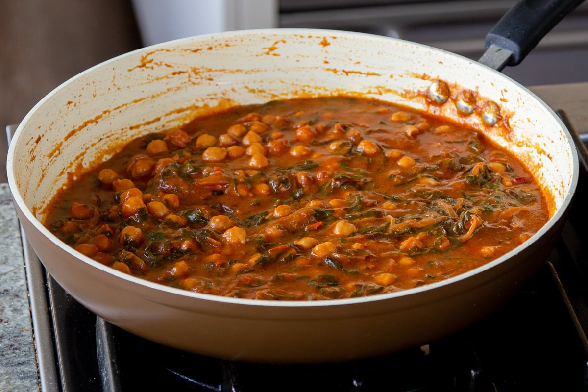 panful of harissa chickpeas after cooking with a glazed top