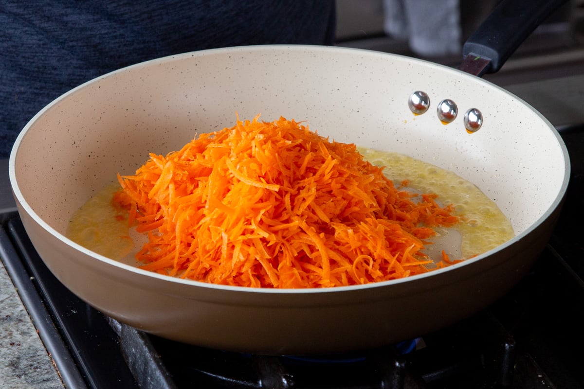 adding shredded carrots to the pan
