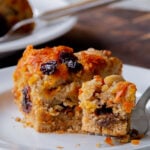 slice of carrot halwa cake on a white plate, with a bite taken out