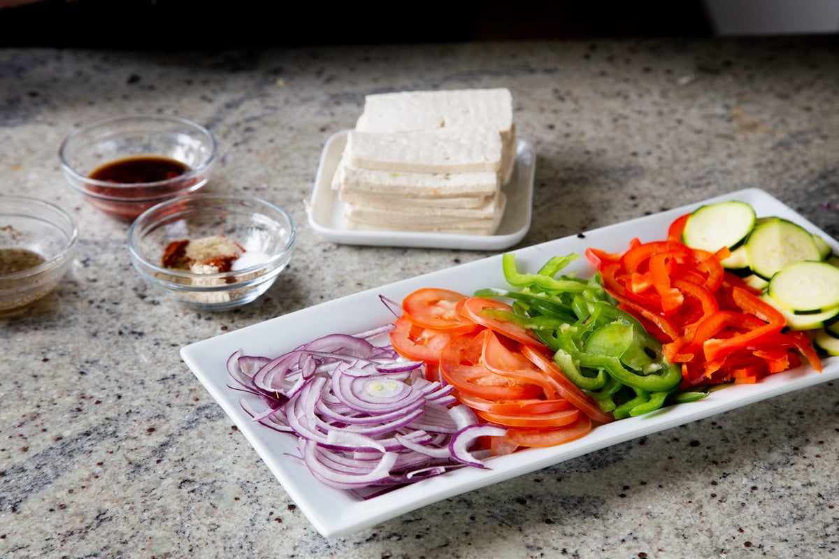 tofu, veggies, and seasonings on a kitchen counter