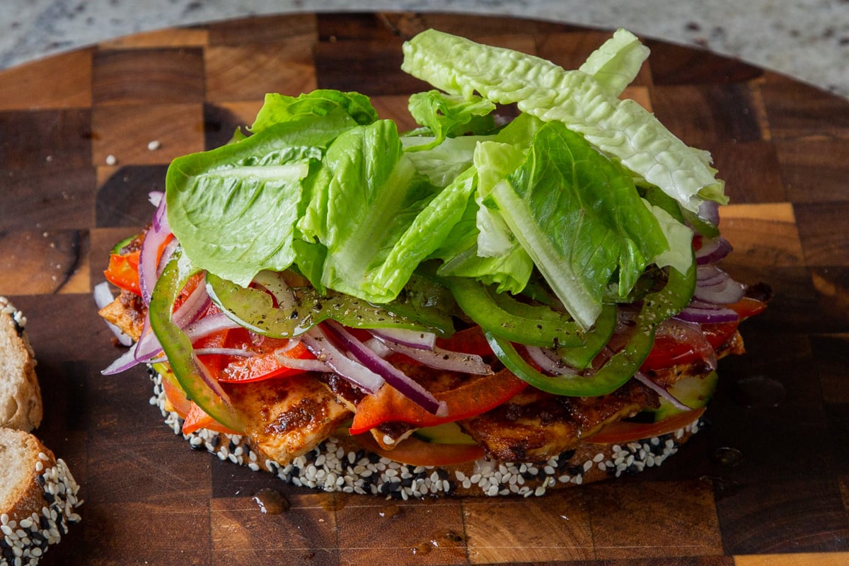 adding the lettuce and vinaigrette to the sandwich