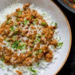 bowl of lasooni dal over rice with cilantro and a swirl of cream