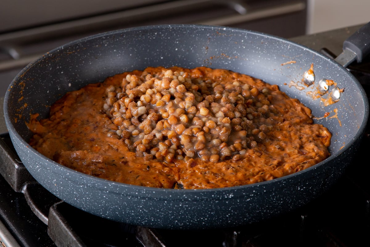 adding the lentils to the pan