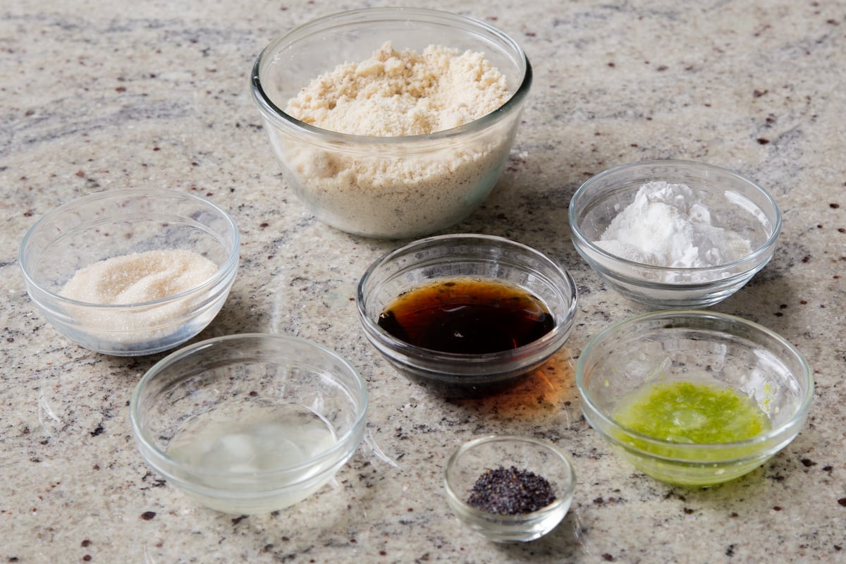 lemon juice and zest, flours, and other cookie ingredients in bowls on a kitchen countertop