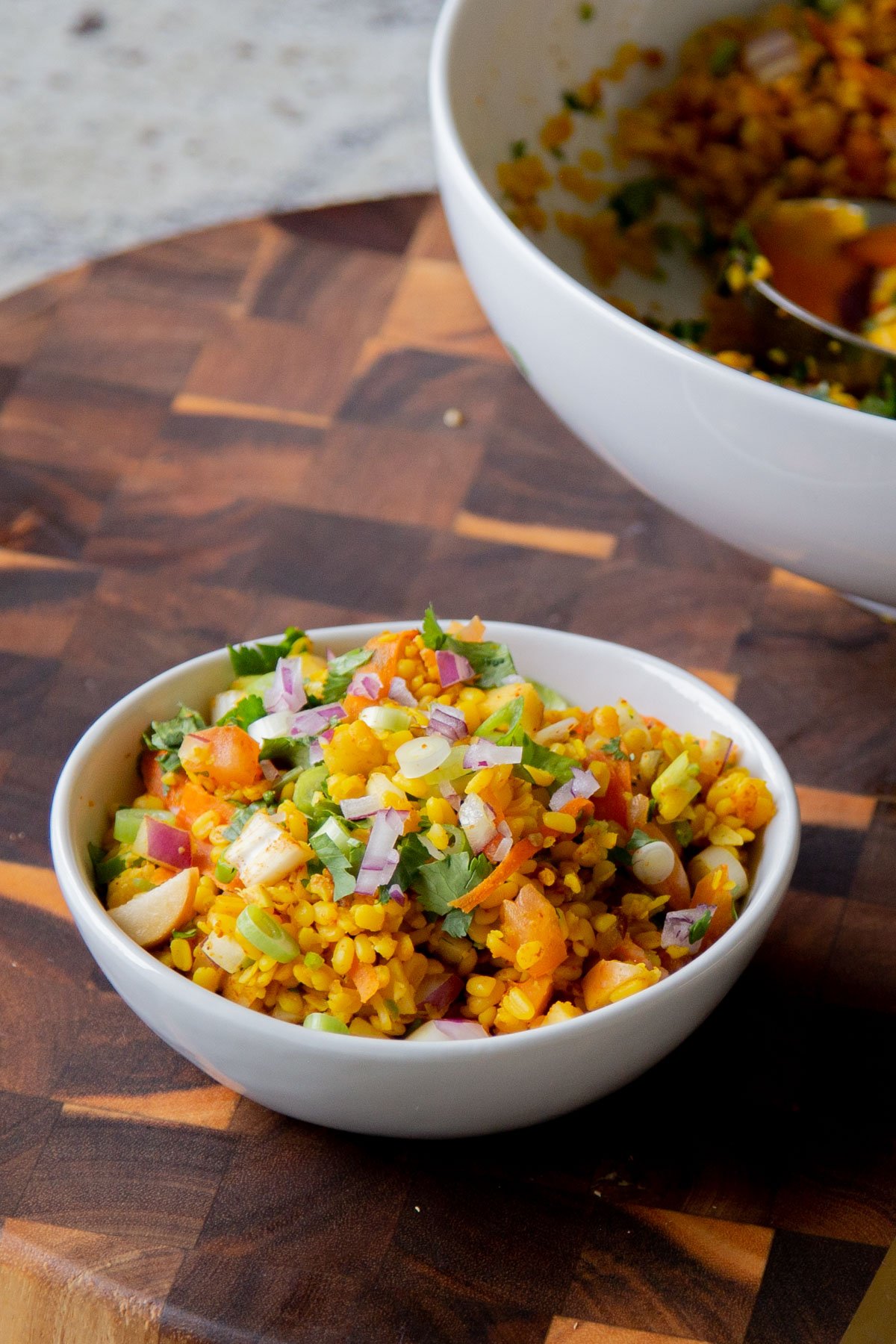 bowl of moong dal chaat next to the serving bowl
