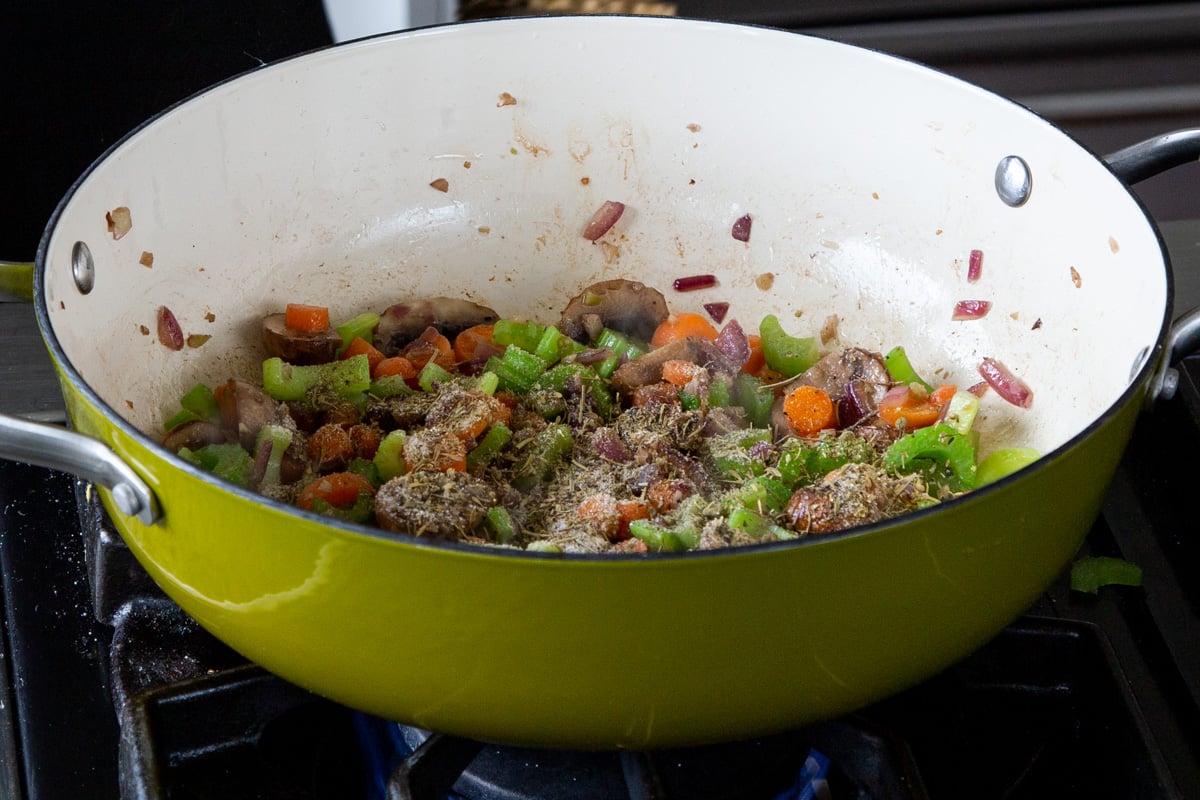 adding sauces and spices to the mushrooms, celery, and carrots, after cooking