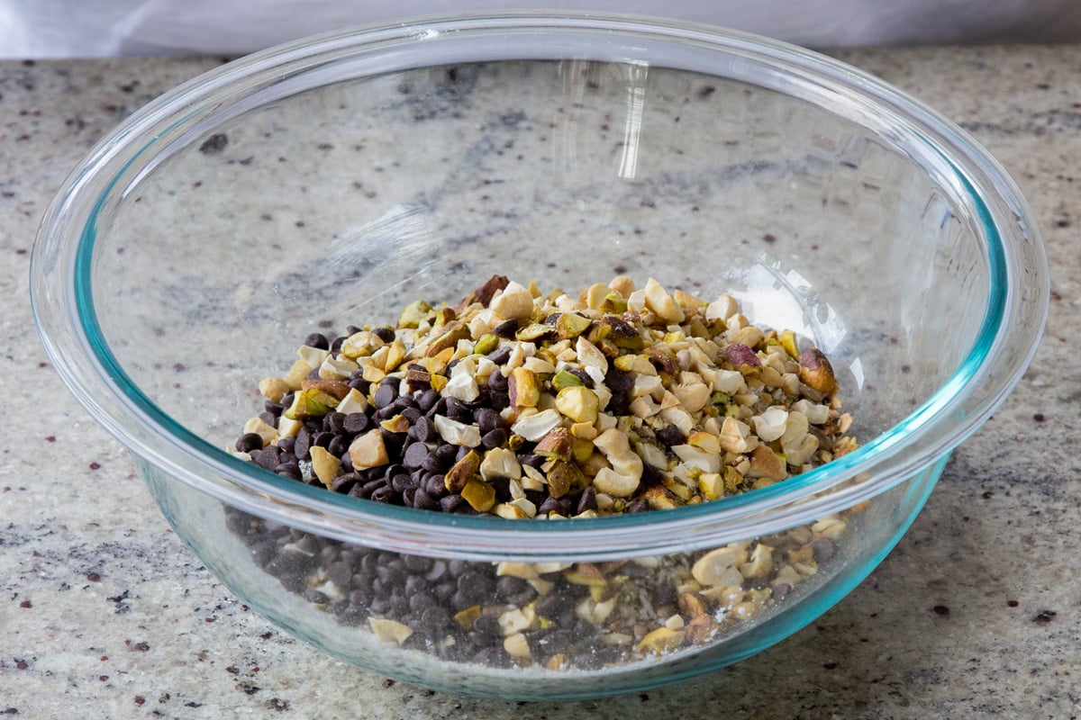 adding chocolate chips and chopped nuts tot he bowl
