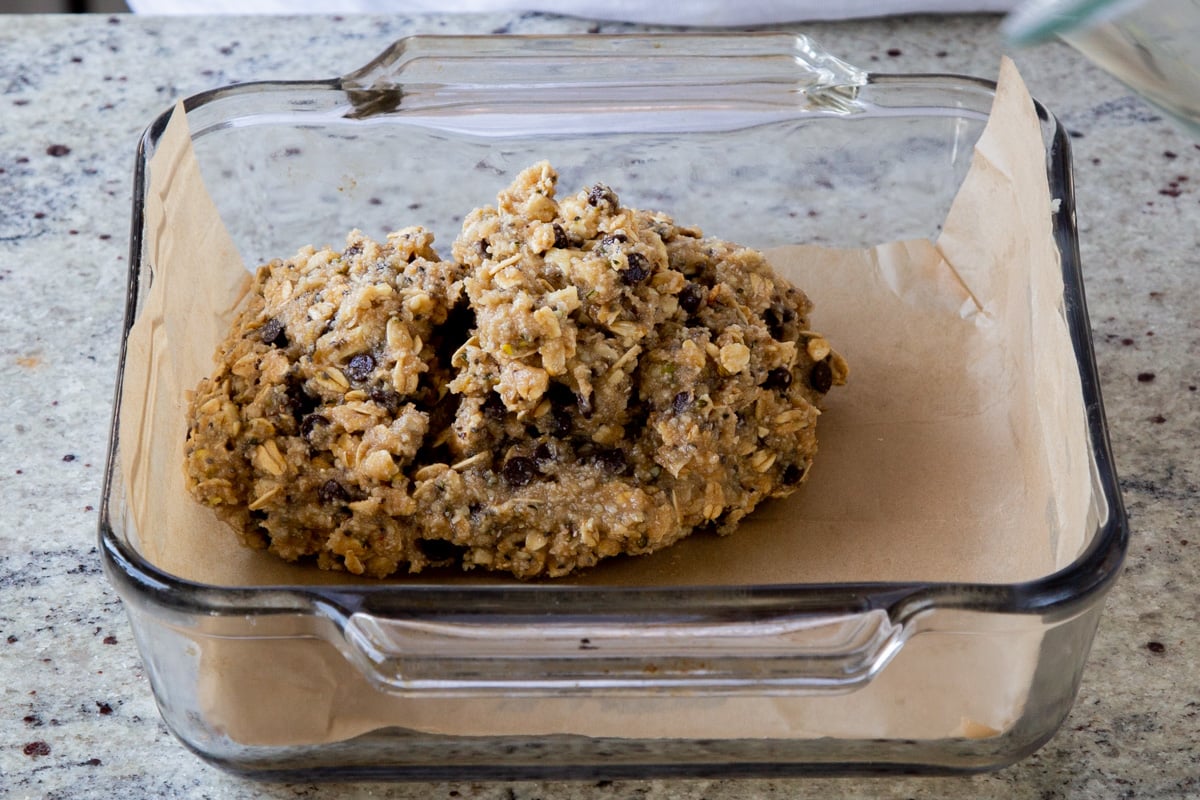 adding the granola bar dough to the baking pan