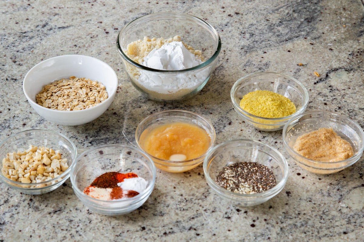 oats, almond flour, and other ingredients in bowls on a kitchen counter