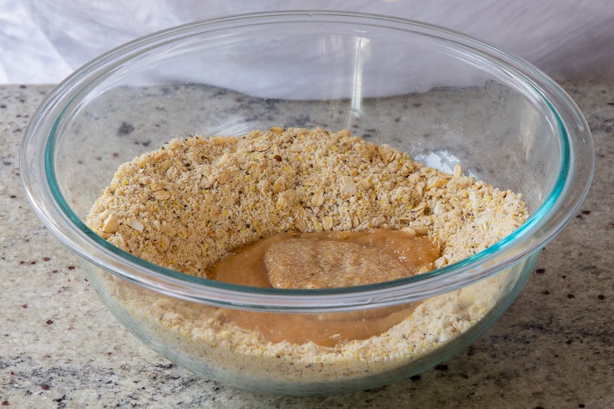 adding wet ingredients to the dry in a mixing bowl