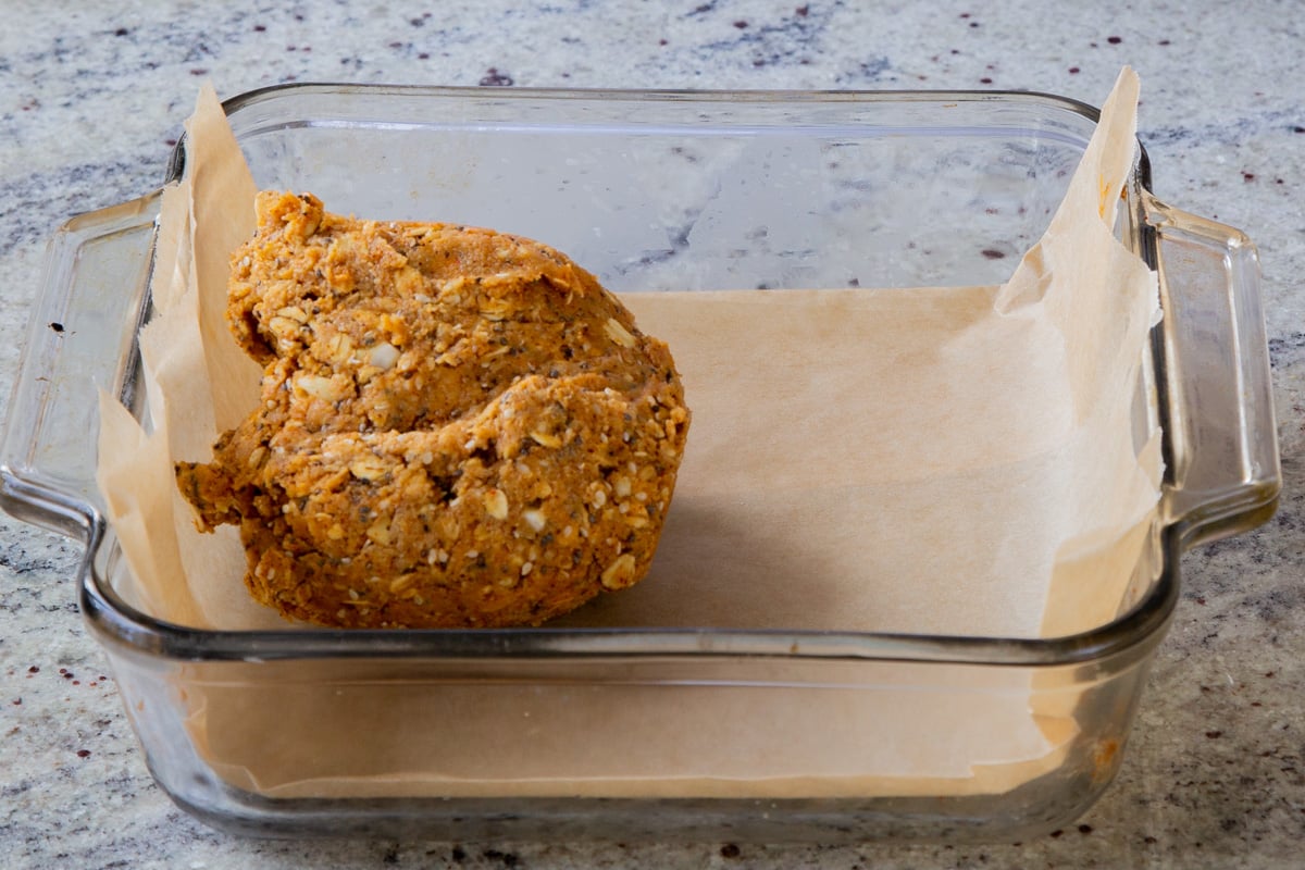 ball of savory granola bar dough in a lined baking sheet