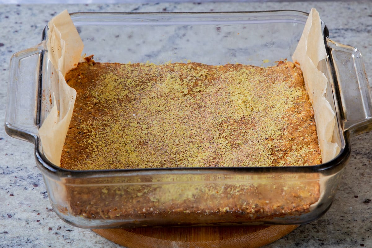 panful of savory granola bar dough with the flavor topping sprinkled on