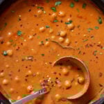 butter chickpeas in the skillet topped with cilantro