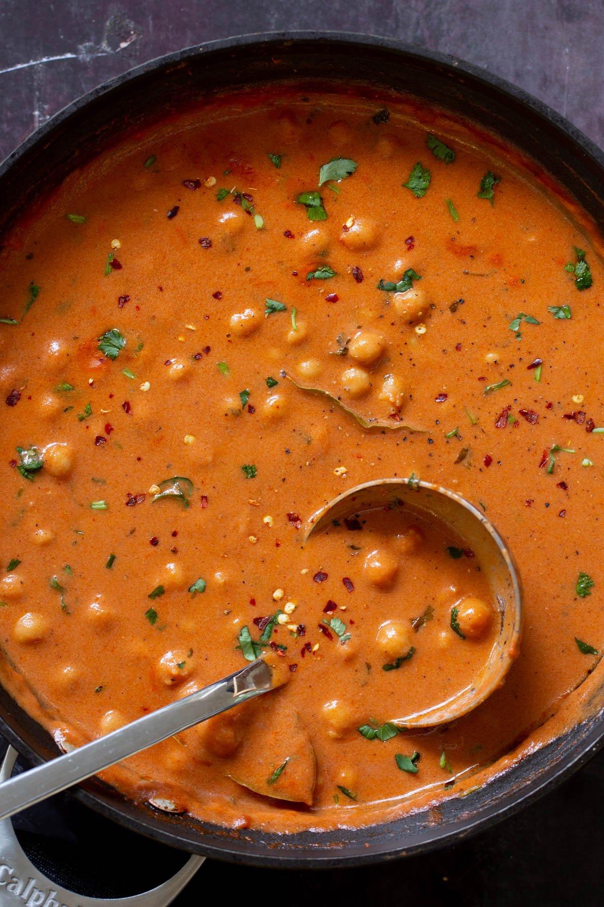 butter chickpeas in the skillet topped with cilantro