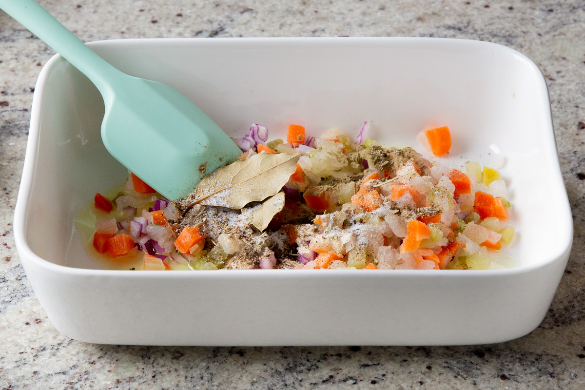 adding spices to the baked veggies in the pan