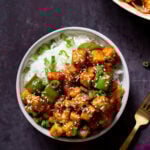 bowl of honey chilli tofu over rice next to the skillet