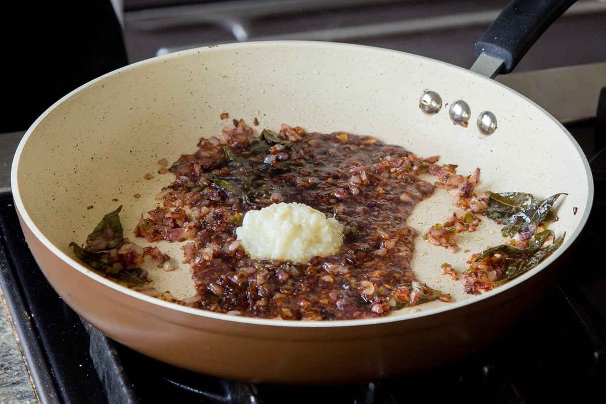 adding ginger garlic paste to the pan of cooked onion mixture