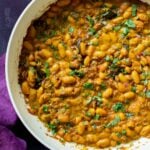 pan of spicy white bean stew with cilantro garnish