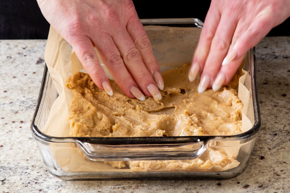 pressing the dough into the lined baking pan