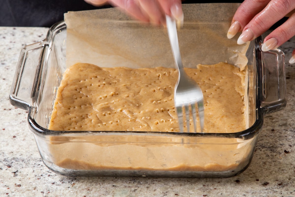 using a fork to pierce holes into the unbaked crust