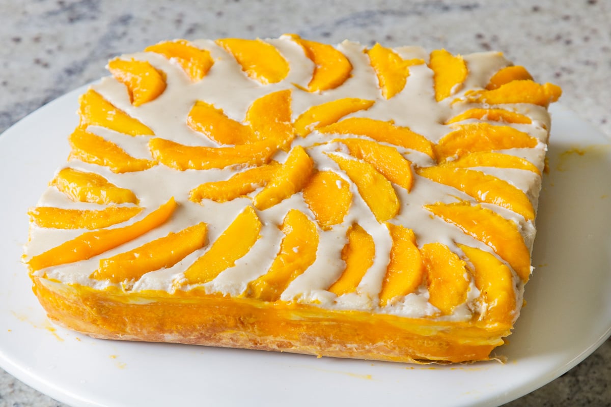 mango tiramisu on a cake stand, before slicing