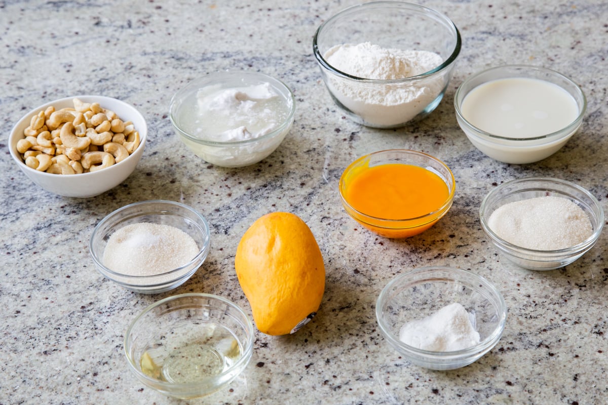 fresh and pureed mango and other tiramisu ingredients in bowls on a kitchen counter