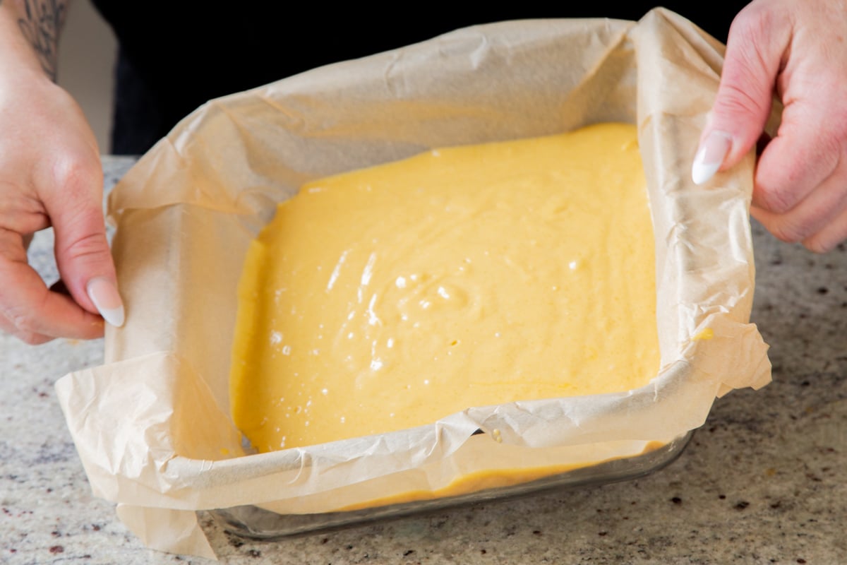 mango cake batter spread out into the baking pan, before baking