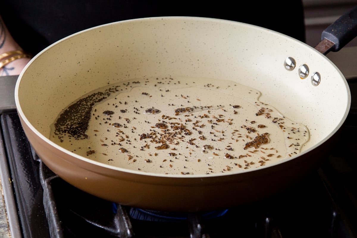 adding whole spices to the hot pan