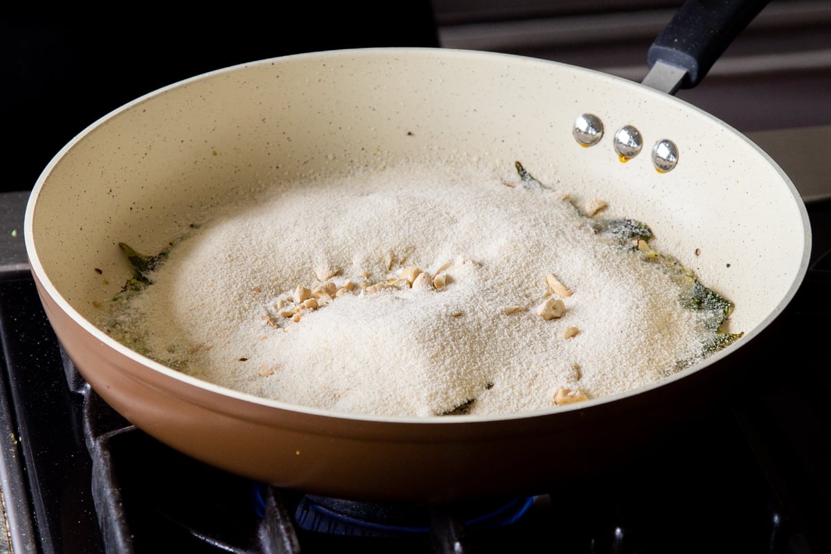 adding semolina to the pan of spices