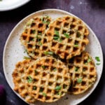 plates of rava idli waffles and pancakes next to a bowl of chutney