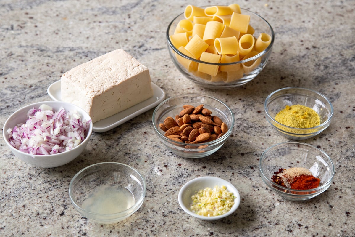 pasta, tofu, and spices in bowls on the kitchen counter