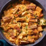 romesco pasta in a skillet with cajun tofu on top