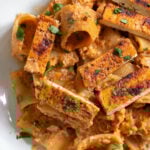 close-up of romesco sauce pasta in a bowl with cajun tofu on top