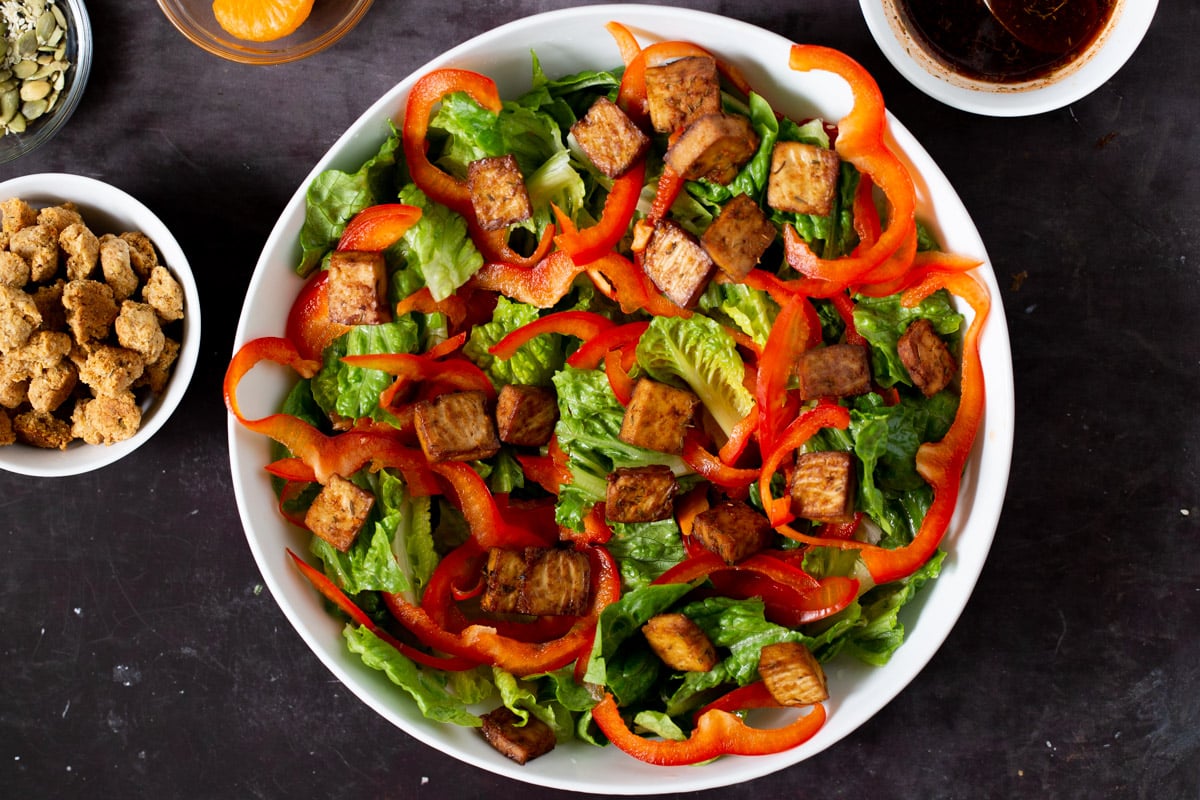 adding tofu to the salad bowl