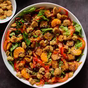 vegan summer salad in a bowl with tofu, croutons, veggies and oranges