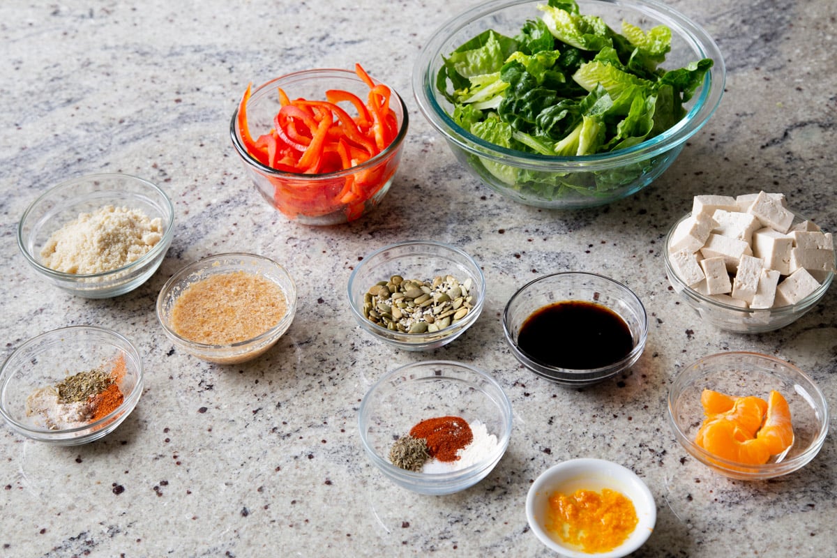 summer salad ingredients in bowls on a kitchen countertop