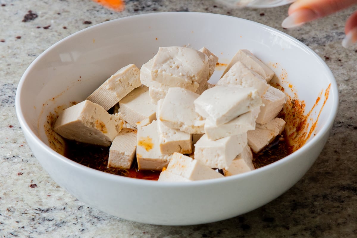 adding tofu to the smoky marinade